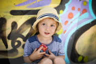 Young Boy sitting in front of a Graffiti Wall