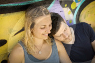 Couple sitting in front of a Graffiti Wall