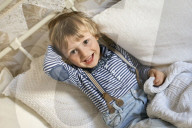 Portrait of a Boy sitting on a Bed