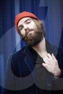 Man with red Beanie posing in front of a blue Container 