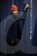Man with red Beanie posing in front of a blue Container 