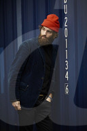 Man with red Beanie posing in front of a blue Container 