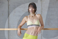 Sporty young Woman leaning on a Ballet Bar