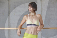 Sporty young Woman leaning on a Ballet Bar