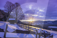 A bee hut beside a mountain farm at sunrise