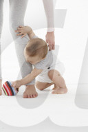 Little boy holding on to mother's leg