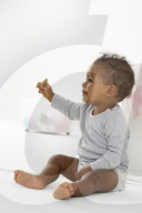 Toddler sitting on the Floor and eating a Cookie
