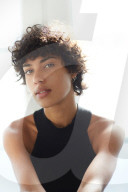 Portrait of a young Woman with ruffled and curly dark Hair