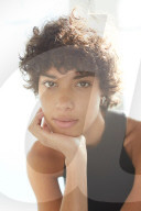 Portrait of a young Woman with ruffled and curly dark Hair
