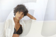 Young Woman in Lingerie sitting on a white Couch 