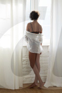Young Woman wearing Lingerie standing at a Window