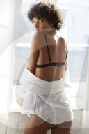 Young Woman wearing Lingerie standing at a Window
