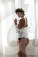 Young Woman wearing Lingerie standing at a Window