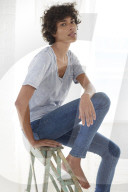 Young woman wearing a T-Shirt and sitting on a wooden Ladder
