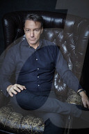 Mature Man sitting on a Leather Wing Chair