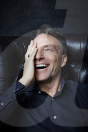 Mature Man sitting on a Leather Wing Chair