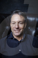 Mature Man sitting on a Leather Wing Chair
