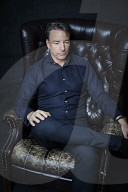 Mature Man sitting on a Leather Wing Chair
