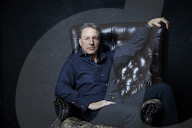Mature Man sitting on a Leather Wing Chair