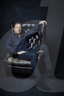 Mature Man sitting on a Leather Wing Chair
