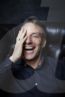 Mature Man sitting on a Leather Wing Chair