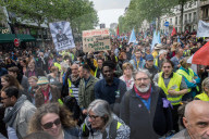 French police have fired tear gas on masked protesters who joined large May Day demonstrations in Paris.