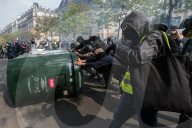 French police have fired tear gas on masked protesters who joined large May Day demonstrations in Paris.