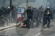 French police have fired tear gas on masked protesters who joined large May Day demonstrations in Paris.