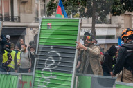 French police have fired tear gas on masked protesters who joined large May Day demonstrations in Paris.