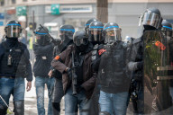 French police have fired tear gas on masked protesters who joined large May Day demonstrations in Paris.