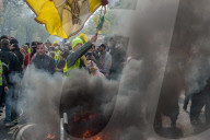 French police have fired tear gas on masked protesters who joined large May Day demonstrations in Paris.