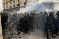 French police have fired tear gas on masked protesters who joined large May Day demonstrations in Paris.