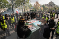 French police have fired tear gas on masked protesters who joined large May Day demonstrations in Paris.