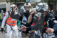 French police have fired tear gas on masked protesters who joined large May Day demonstrations in Paris.