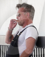 EXKLUSIV - John Mellencamp wartet in schwarzen Latzhosen auf seinen Flug