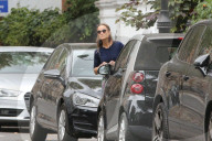 Pippa Middleton peeps around a parked car as she tries to hail a taxi in Central London