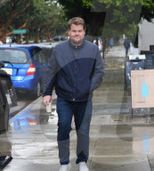 PREMIUM EXCLUSIVE Grumpy James Corden Braves The Rain For His Morning Coffee