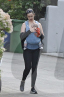 Hollywood actress Krysten Ritter is every inch the protective mommy as she carries her infant son Bruce in a baby harness.