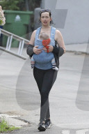 Hollywood actress Krysten Ritter is every inch the protective mommy as she carries her infant son Bruce in a baby harness.