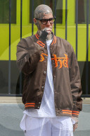 Rapper Rick Hilfiger appears to smoke a suspicious cigarette as he relaxes on the streets of LA despite the coronavirus shutdown