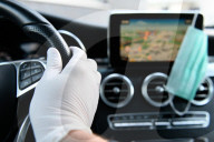 NEWS - Coronavirus: Symbolbild einer Schutzmaske und Handschuh im Auto