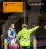Passengers arrive at Heathrow Terminal 4 in masks. 