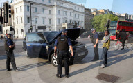 Armed Police stop to assist a motorist after his Range Rover broke down, they pushed it out of the Road at Hyde Park Corner.