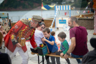 'Telly just isn't the same': glorious return of English seaside entertainment. People young and old enjoy silly fun of Uncle Tacko’s flea circus and a Punch and Judy show in Devon