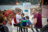 'Telly just isn't the same': glorious return of English seaside entertainment. People young and old enjoy silly fun of Uncle Tacko’s flea circus and a Punch and Judy show in Devon