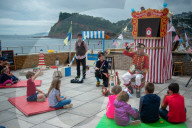 'Telly just isn't the same': glorious return of English seaside entertainment. People young and old enjoy silly fun of Uncle Tacko’s flea circus and a Punch and Judy show in Devon