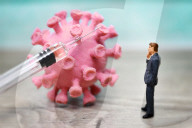 NEWS - Coronavirus: Figur vor Coronavirus mit Impfspritze