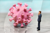 NEWS - Coronavirus: Figur vor Coronavirus mit Impfspritze