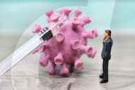 NEWS - Coronavirus: Figur vor Coronavirus mit Impfspritze