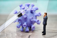 NEWS - Coronavirus: Figur vor Coronavirus mit Impfspritze